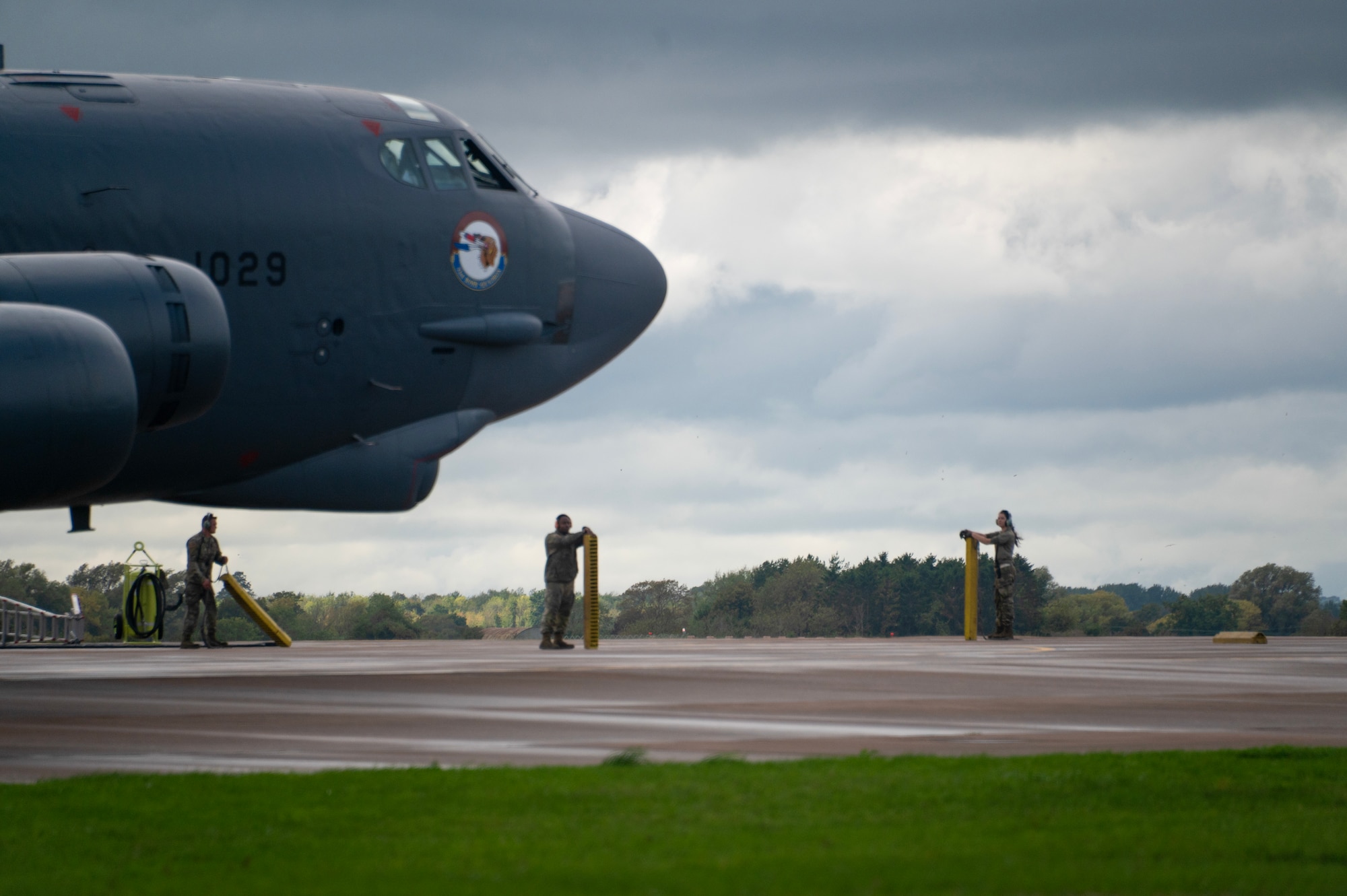 Three U.S. Air Force Airmen, assigned to the 307th Bomb Wing, Barksdale Air Force Base, Louisiana, hold wheel chalks as a B-52H Stratofortress aircraft taxis to park during Exercise Cobra Warrior 25-2 at RAF Fairford, England, Sept. 18, 2025. As a Reserve unit with deep operational experience, the 307th demonstrates the value of Total Force Integration, blending Reserve and Active-Duty capabilities with Allied counterparts. (U.S. Air Force photo by Staff Sgt. Tambri Cason)