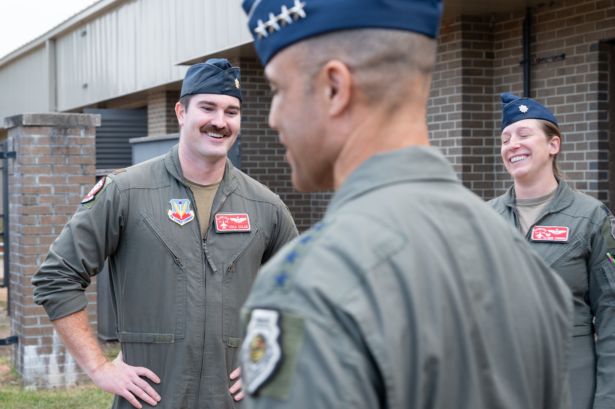 Two Air Force officers smiling while having a conversation with the COMACC.