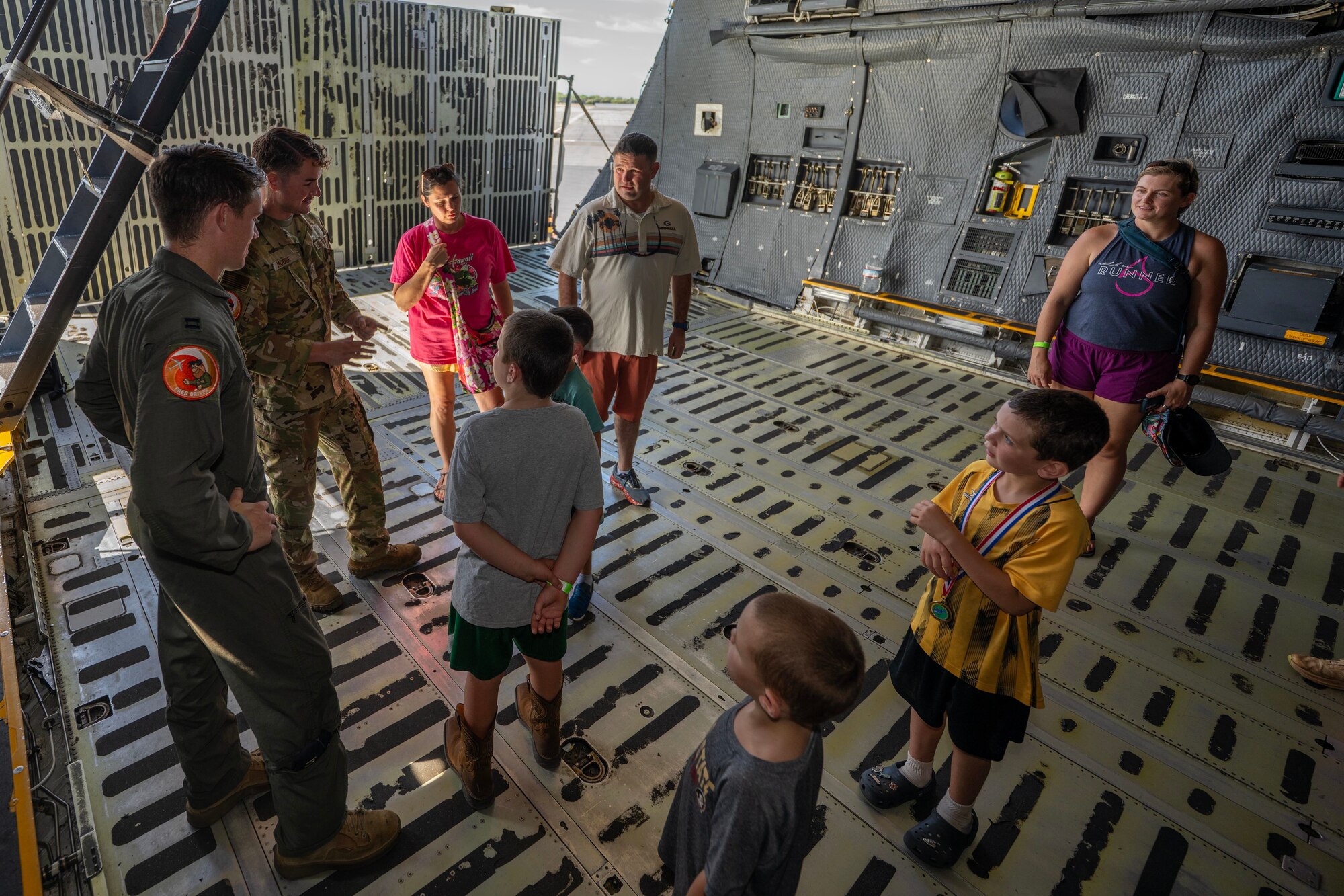Airmen and civilians speak inside of an aircraft.