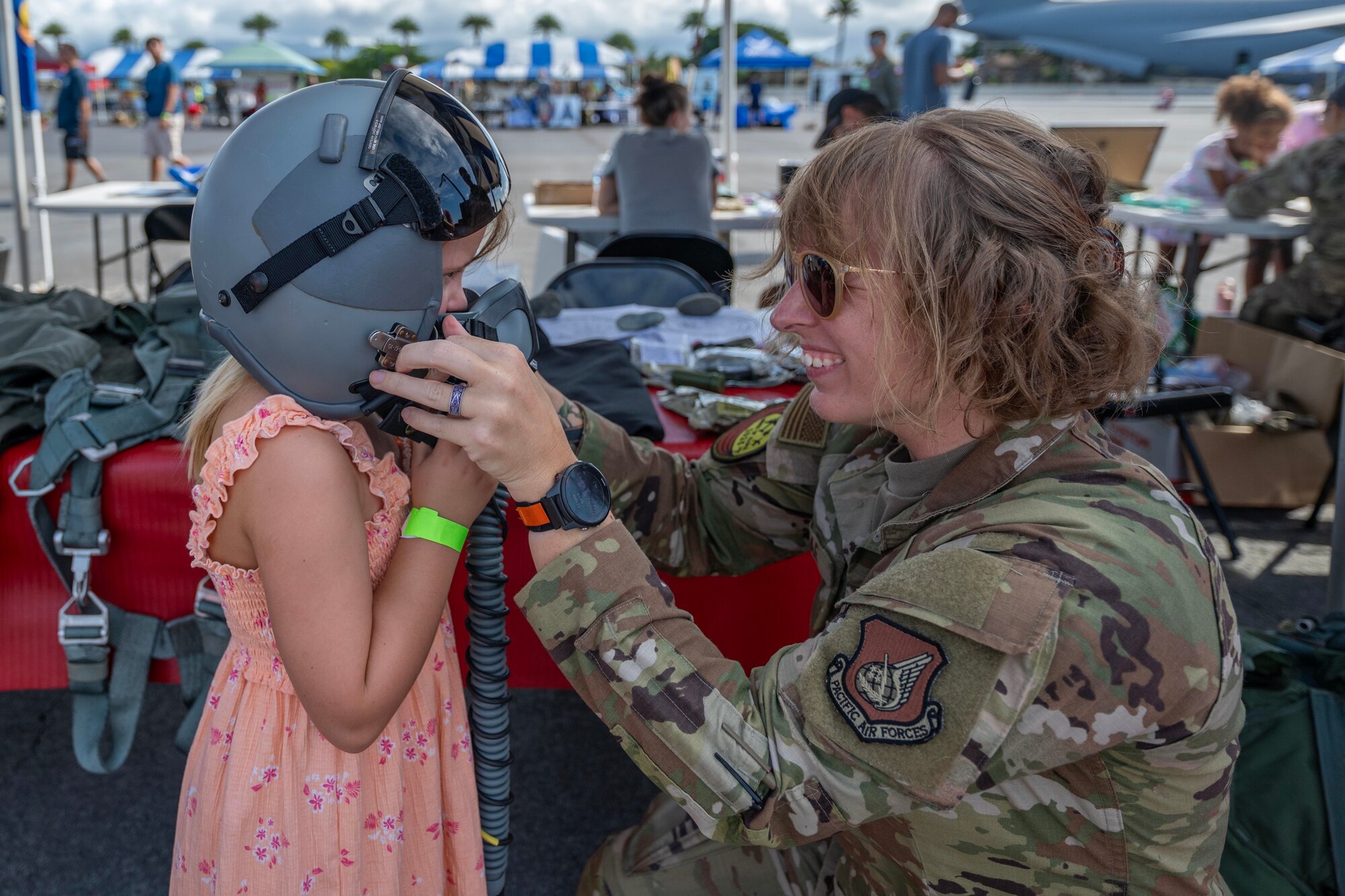 Airmen putting a helmet on child.