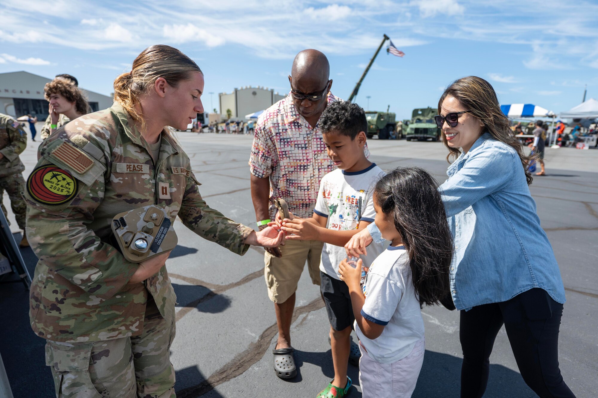 Airman shows a wind speed meter to children.