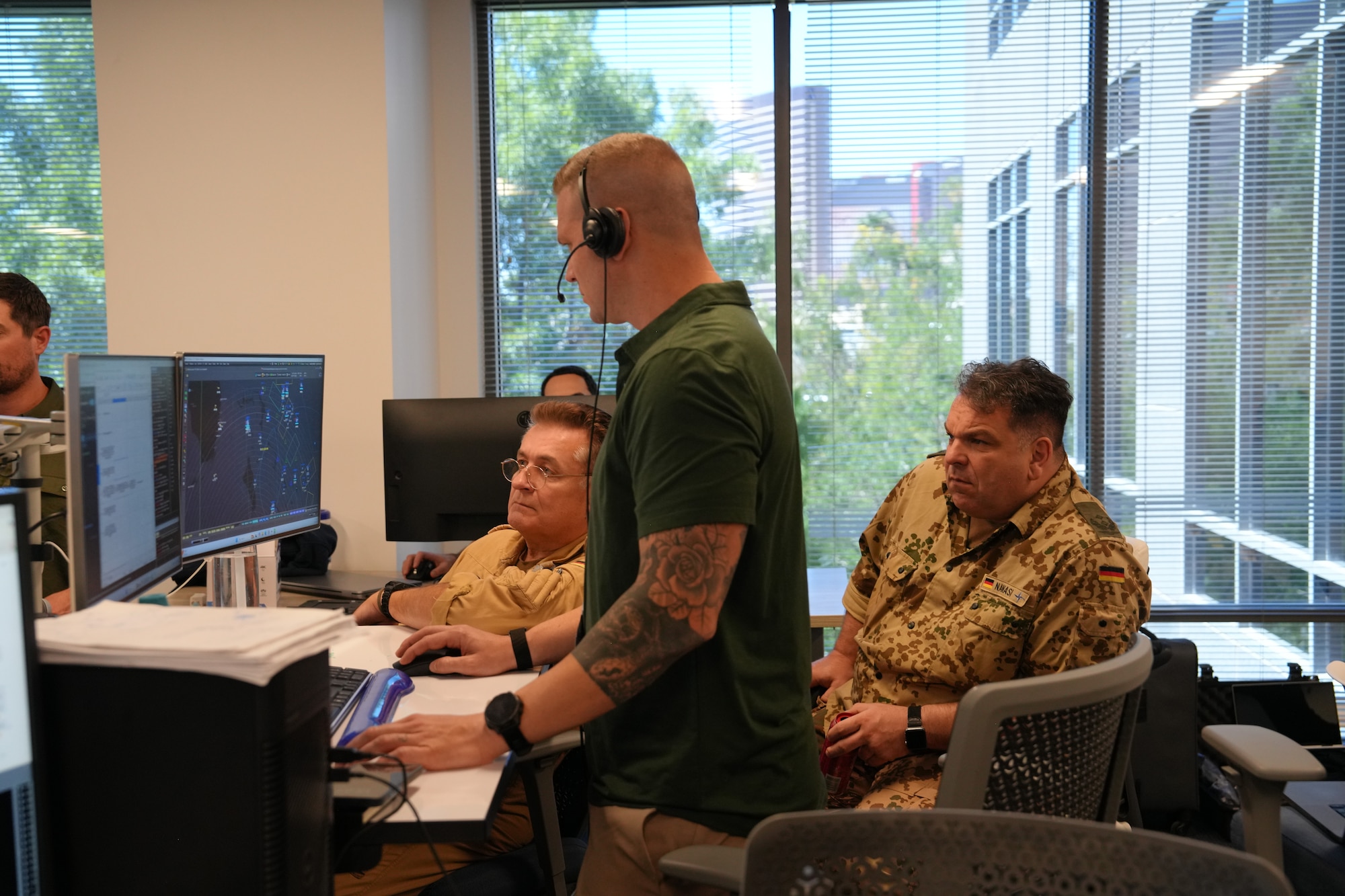 people standing and sitting looking at computer screens