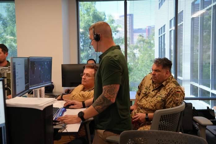people standing and sitting looking at computer screens