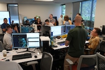 people standing and sitting looking at computer screens