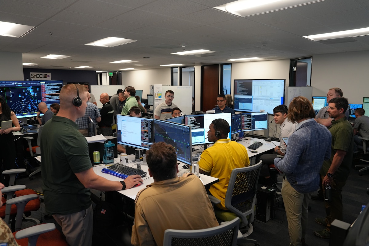 people standing and sitting looking at computer screens