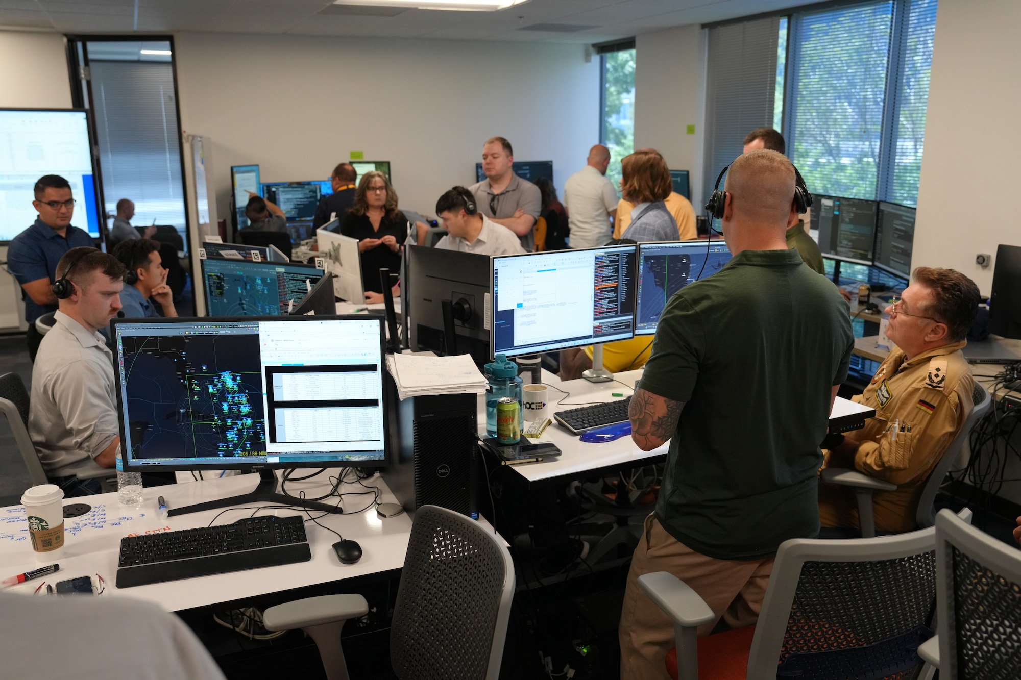people standing and sitting looking at computer screens