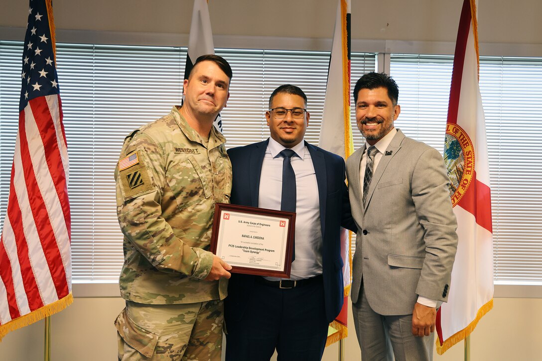 Maj. Matthew A. Westcott, U.S. Army Corps of Engineers Jacksonville’s Deputy District commander, and Howard (Howie) Gonzales, Deputy District Engineer for Programs and Project Management presents  Larbi Kandil, a graduation certificate after completing the U.S. Army Corps of Engineers Jacksonville District celebrated the completion and graduation of the 2025 Leadership Development Program Course during a ceremony at district headquarters at the Prudential Building on Jacksonville’s Southbank.(USACE photo by Bri Sanchez)