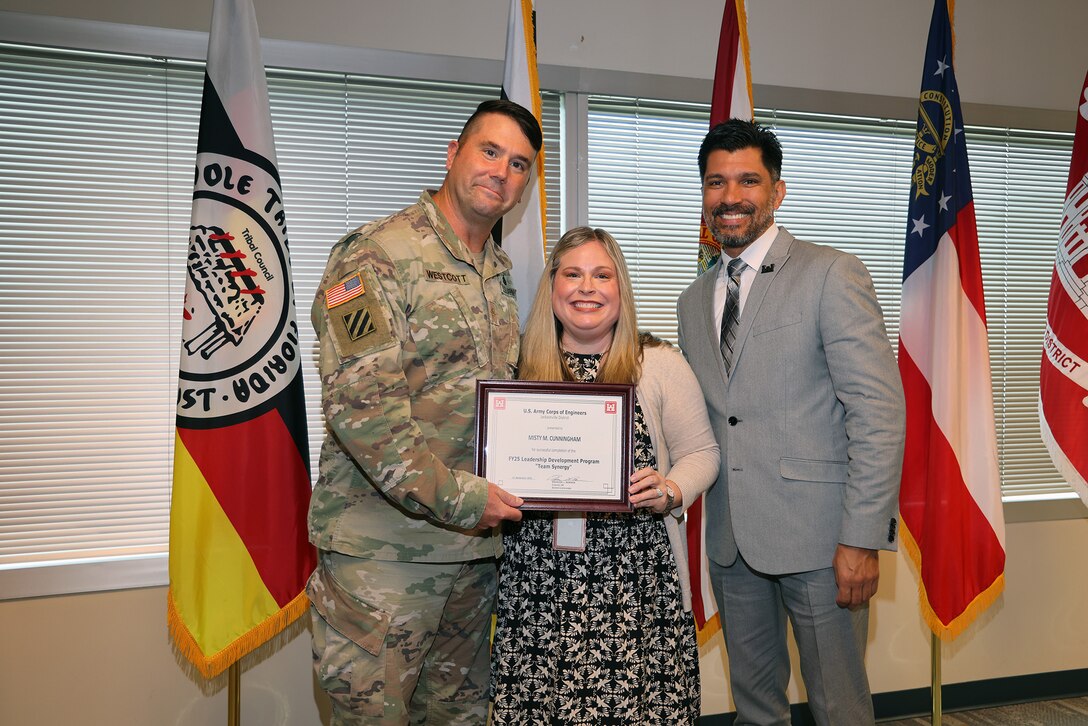 Maj. Matthew A. Westcott, U.S. Army Corps of Engineers Jacksonville’s Deputy District commander, and Howard (Howie) Gonzales, Deputy District Engineer for Programs and Project Management presents  Larbi Kandil, a graduation certificate after completing the U.S. Army Corps of Engineers Jacksonville District celebrated the completion and graduation of the 2025 Leadership Development Program Course during a ceremony at district headquarters at the Prudential Building on Jacksonville’s Southbank.(USACE photo by Bri Sanchez)