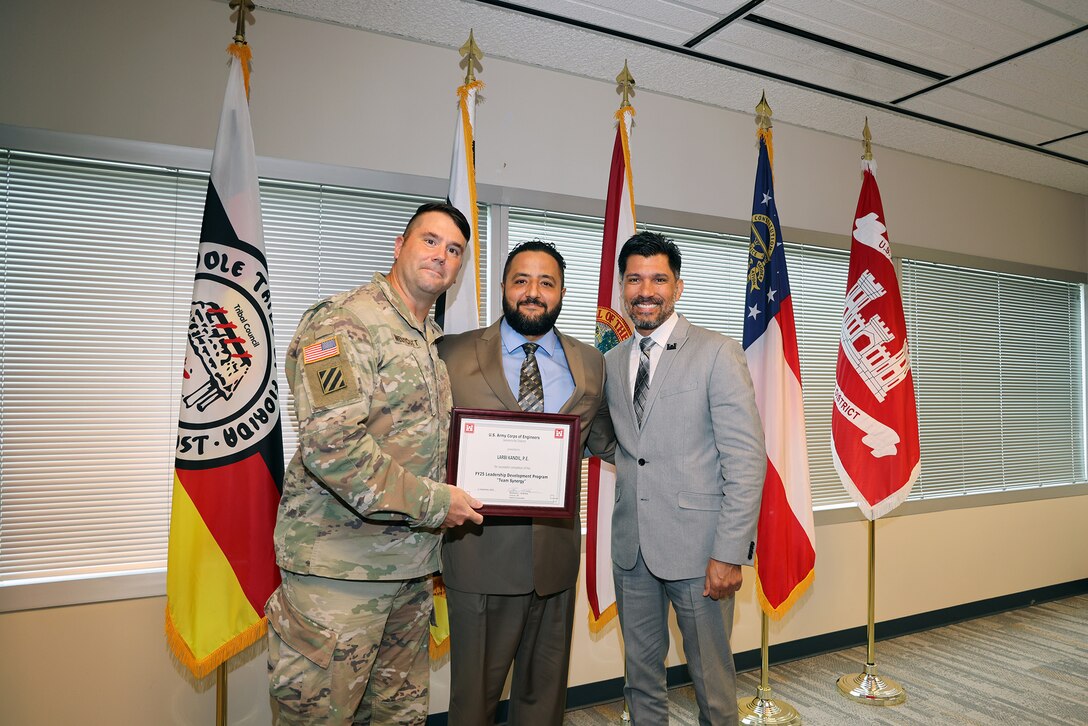 Maj. Matthew A. Westcott, U.S. Army Corps of Engineers Jacksonville’s Deputy District commander, and Howard (Howie) Gonzales, Deputy District Engineer for Programs and Project Management presents  Larbi Kandil, a graduation certificate after completing the U.S. Army Corps of Engineers Jacksonville District celebrated the completion and graduation of the 2025 Leadership Development Program Course during a ceremony at district headquarters at the Prudential Building on Jacksonville’s Southbank.(USACE photo by Bri Sanchez)