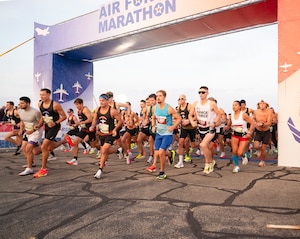 Competitors run under an arch that says "Air Force Marathon"