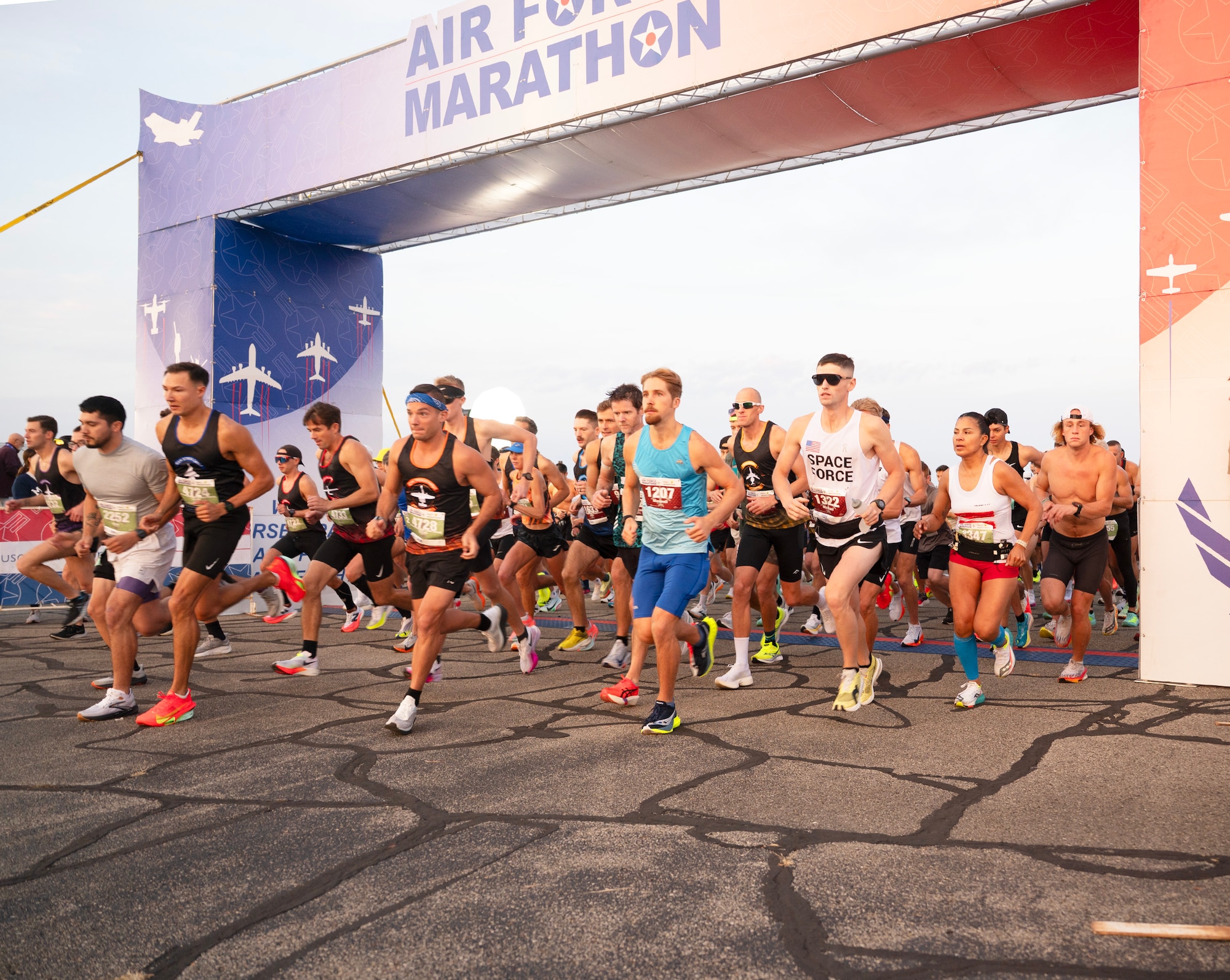Competitors run under an arch that says "Air Force Marathon"