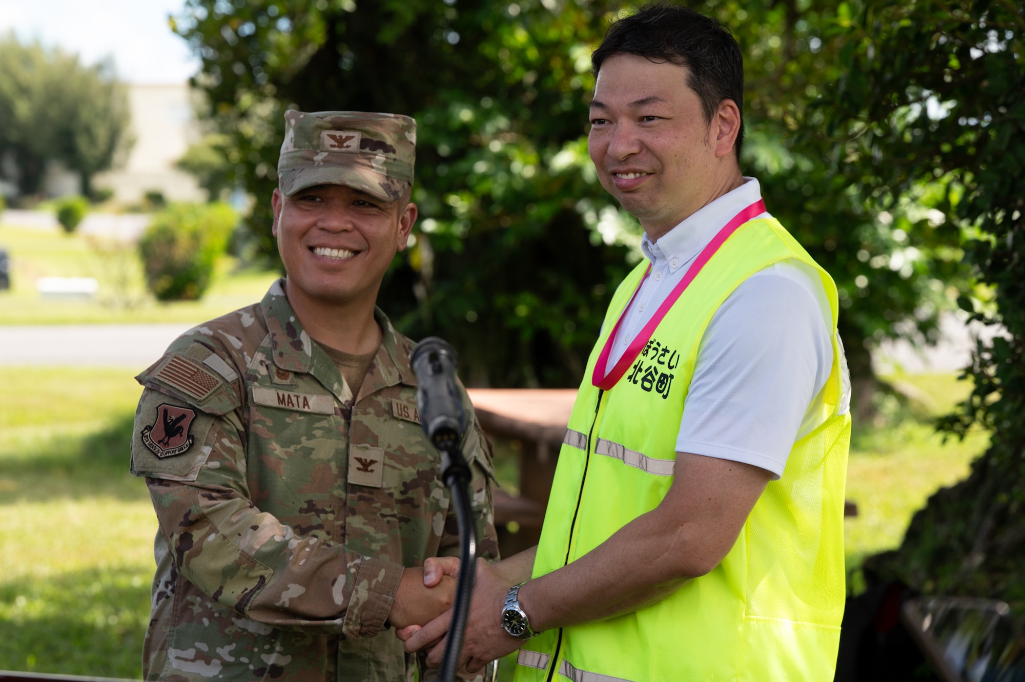 Col. Robinson Mata and Masashi Toguchi shake hands following a press confrence.