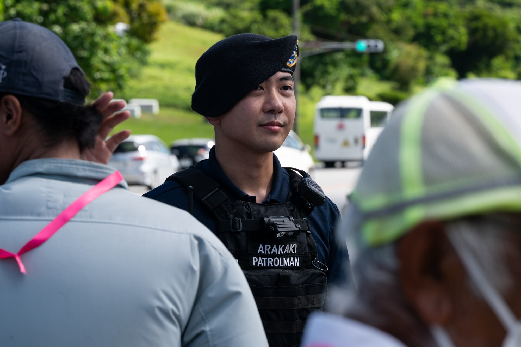 A civilian police officer guides a group through an evacuation route.