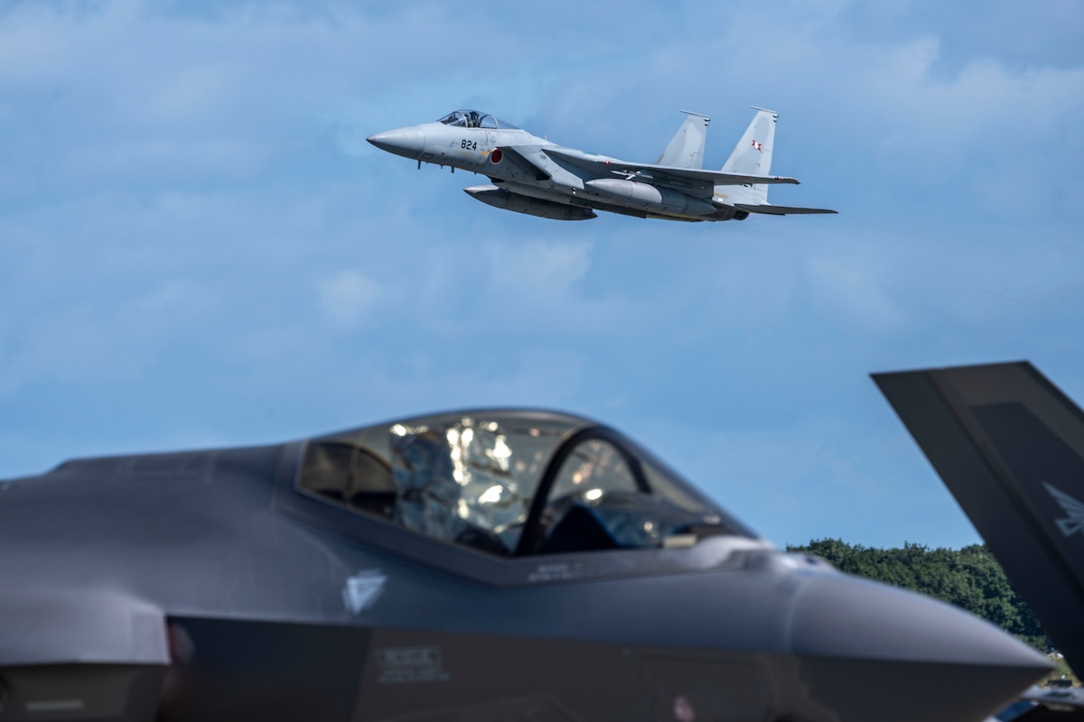 A Japan Air Self Defense Force (JASDF) F-15E Strike Eagle flies over a JASDF F-35 Lightning II during Air Fest 2025 at Misawa Air Base, Japan, Sept. 21, 2025.