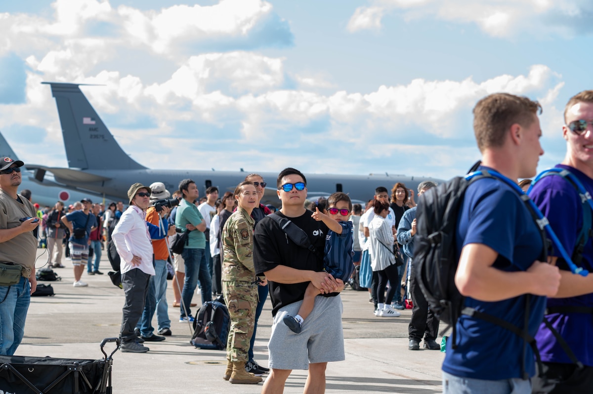 A local father and son watch aerial demonstrations during Misawa Air Fest on Misawa Air Base, Japan, Sept. 21, 2025.