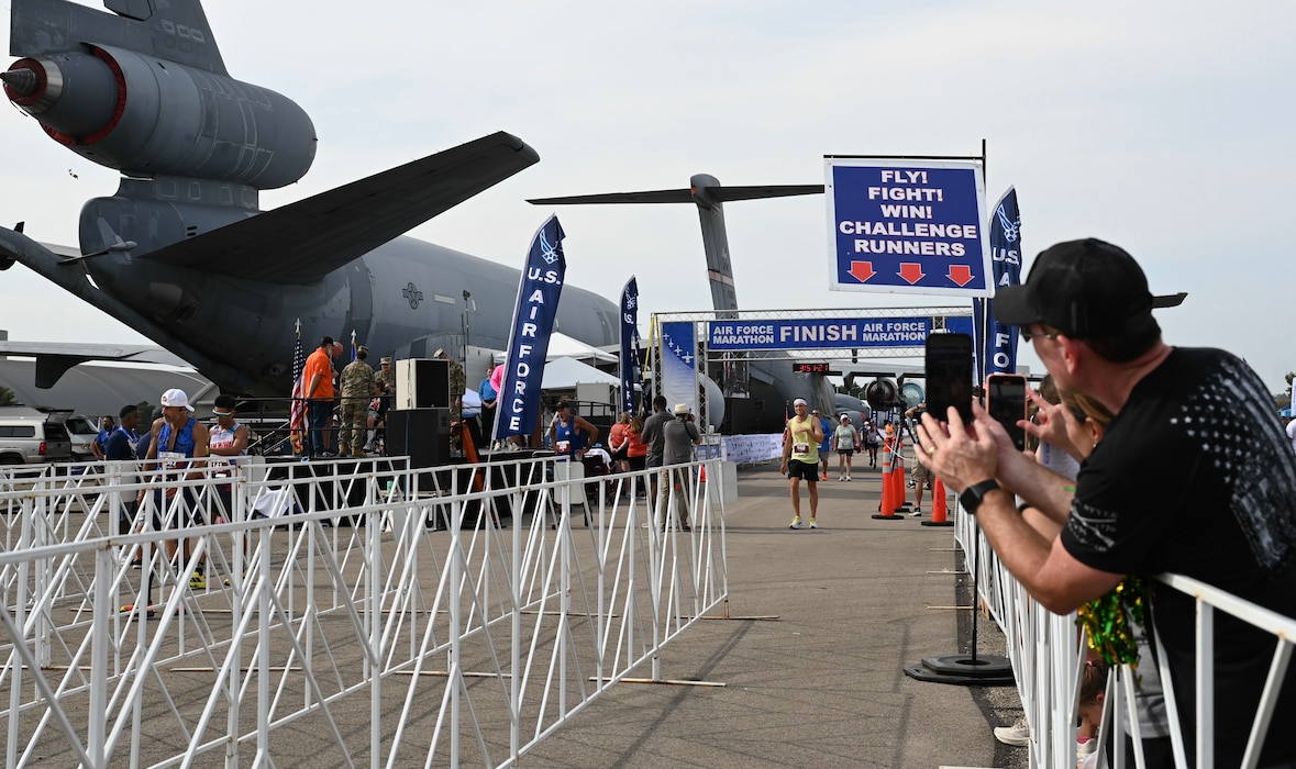 Spectators cheer before reuniting with participants at the finish line of the Air Force Marathon at Wright-Patterson Air Force Base, Ohio, Sept. 20, 2025. Each year, the marathon's finisher's medal presentation features a different aircraft, for the 2025 event, a KC-135 Stratotanker was highlighted. (U.S. Air Force photo by Staff Sgt. Johnathan Quiñones)