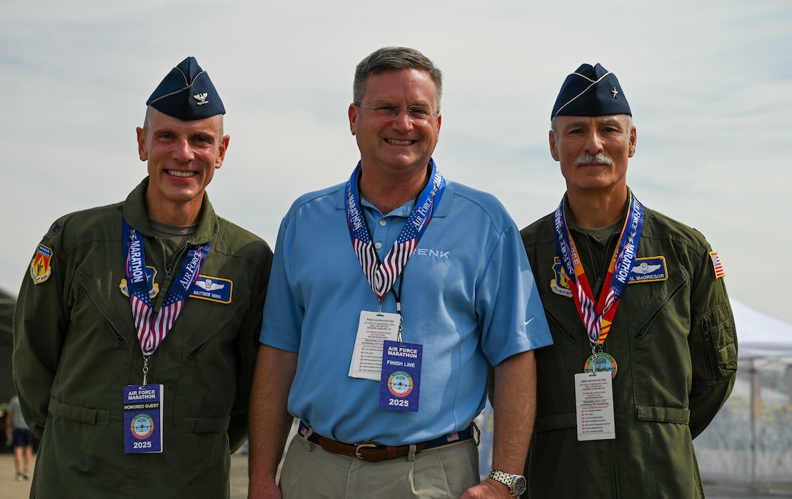 U.S. Air Force Col. Matthew T. Muha, left, 445th Airlift Wing deputy commander; retired Brig. Gen. Karl McGregor, right; and retired Brig. Gen. Robert Palmer, middle, pose for a photo during the 29th annual Air Force Marathon at Wright-Patterson Air Force Base, Ohio, Sept. 20, 2025. As part of Operation Honor 2025, veterans were on hand to cheer on runners and present medals to winners while also engaging with younger generations of service members before tomorrow's historic Honor Flight on an Air Force Reserve C-17 Globemaster III assigned to the 445th Airlift Wing. (U.S. Air Force photo by Staff Sgt. Johnathan Quiñones)