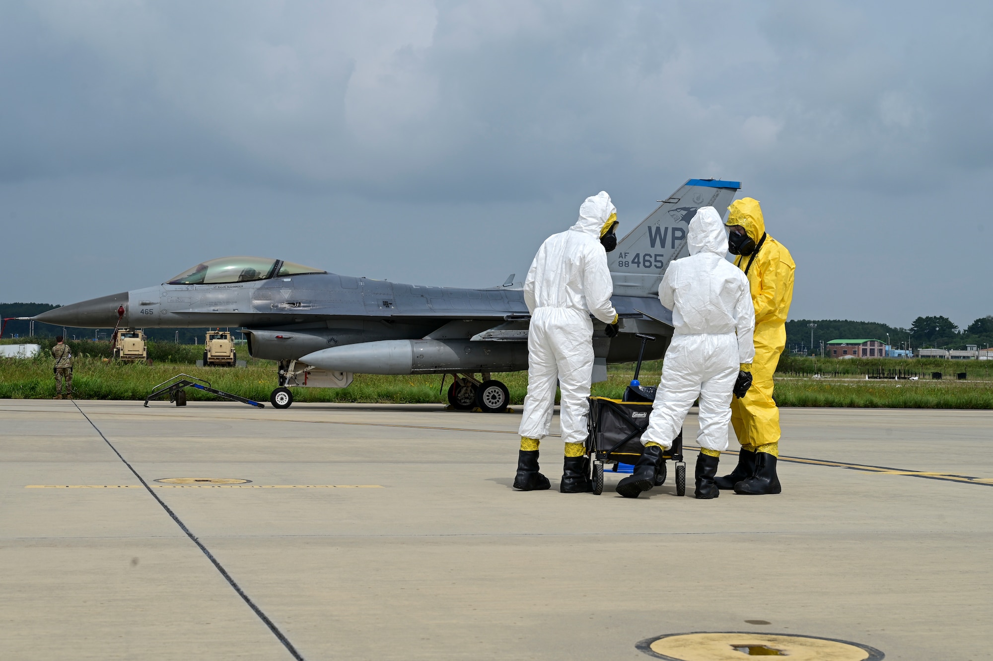 A group stands near a fighter jet.