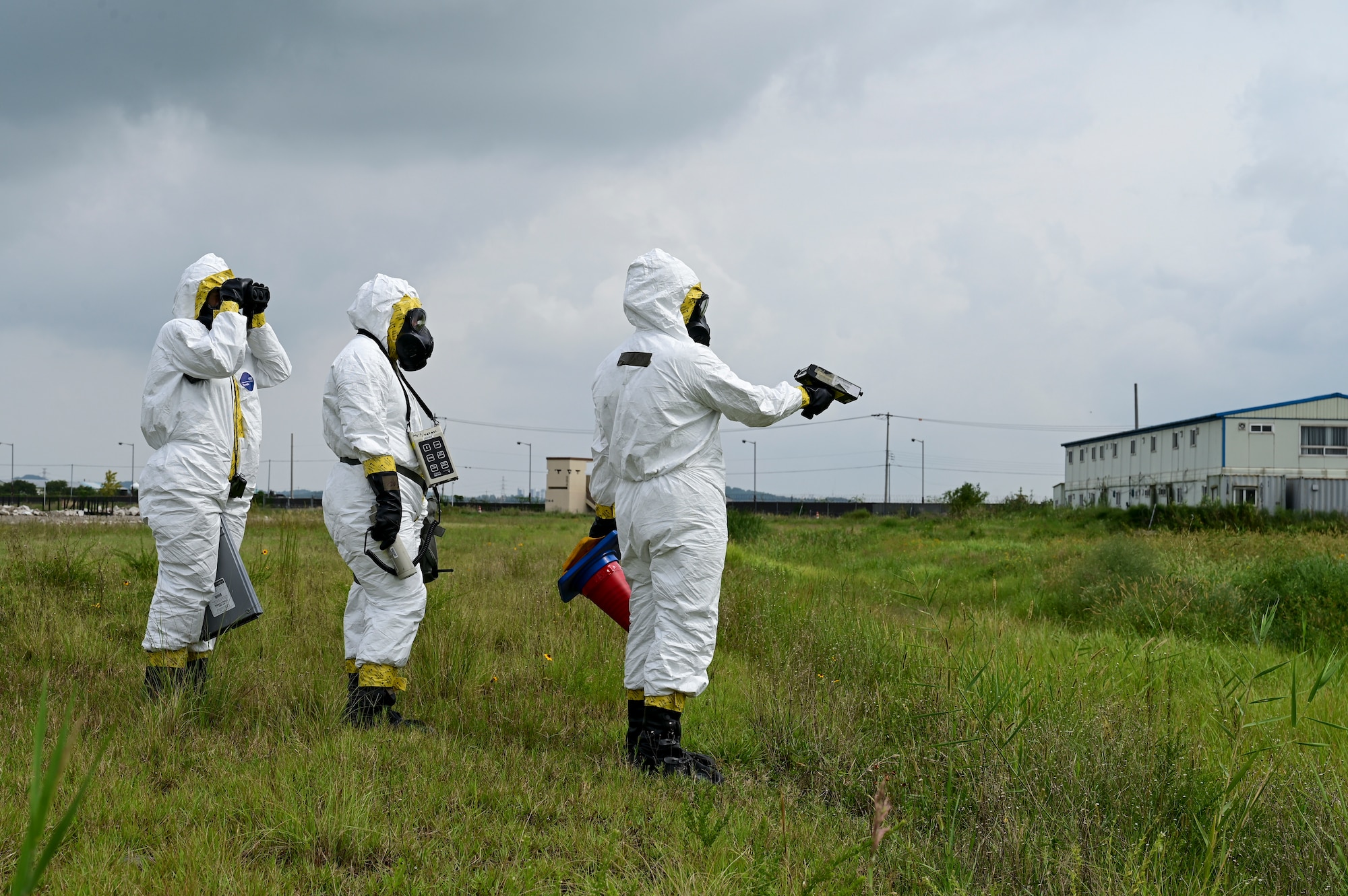 A group stands in the grass holding a scanner.