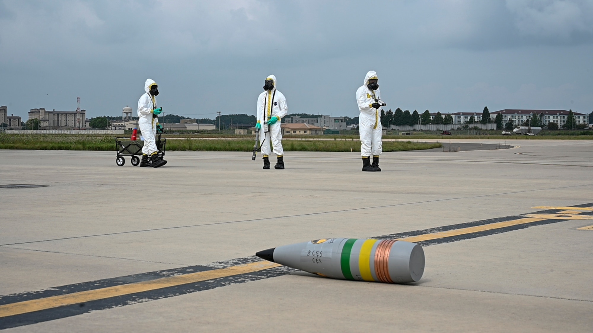A group stands in the distance from a training munition.