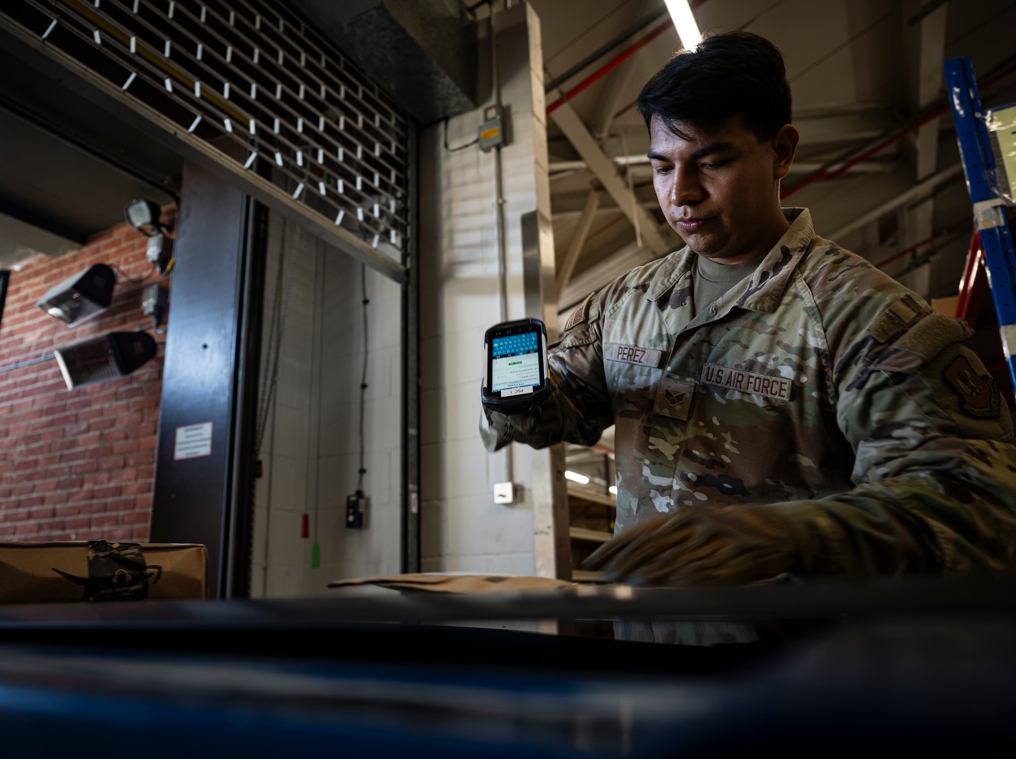 U.S. Air Force Senior Airman Christopher Perez, 100th Force Support Squadron postal clerk, scans packages passed along the conveyor belt at RAF Mildenhall, England, Sept. 19, 2025.