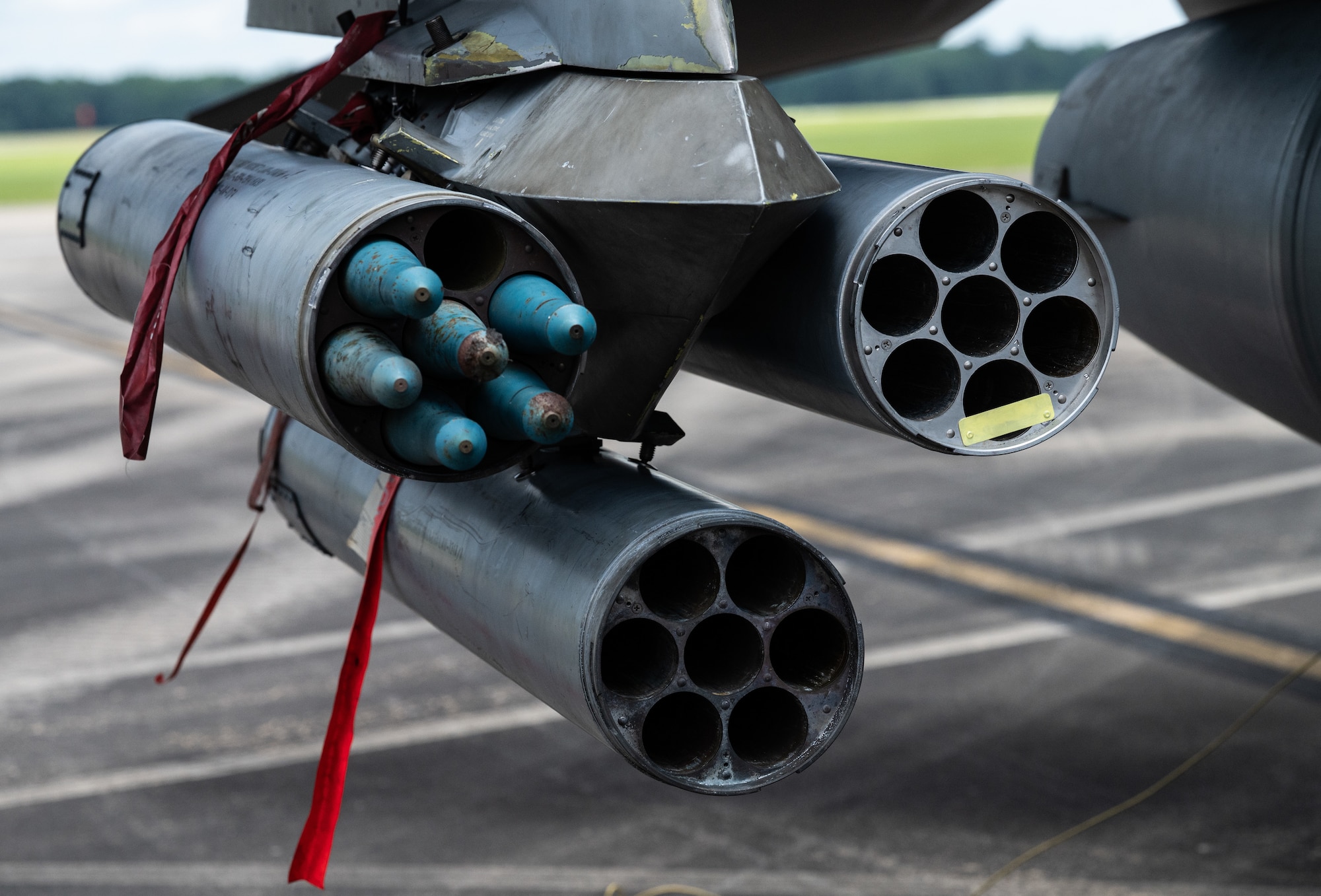 A close up of a jet's missile rail where you can see one rocket pod loaded with rockets