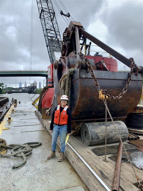 U.S. Army Corps of Engineers, Buffalo District Army Fellow Jane Clark stands on a dredging barge during a site visit to observe dredging of the Cuyahoga River in Cleveland.