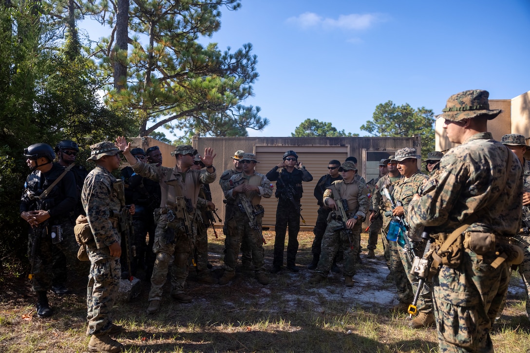 U.S. Marines with 2nd Battalion, 2nd Marine Regiment, discuss room clearing strategies with marines from 1er Batallón de Infantería de Marina (Honduras 1st Marine Infantry Battalion), and Cuerpo de Infantería de Marina (Chilean marine Corps), during exercise UNITAS 2025 at Marine Corps Base Camp Lejeune, North Carolina, Sept. 19, 2025. UNITAS, which is Latin for “unity,” was conceived in 1959 and has taken place annually since first conducted in 1960. This year marks the 66th iteration of the world’s longest running annual multinational maritime exercise. (U.S. Marine Corps photo by Lance Cpl. Payton Goodrich)