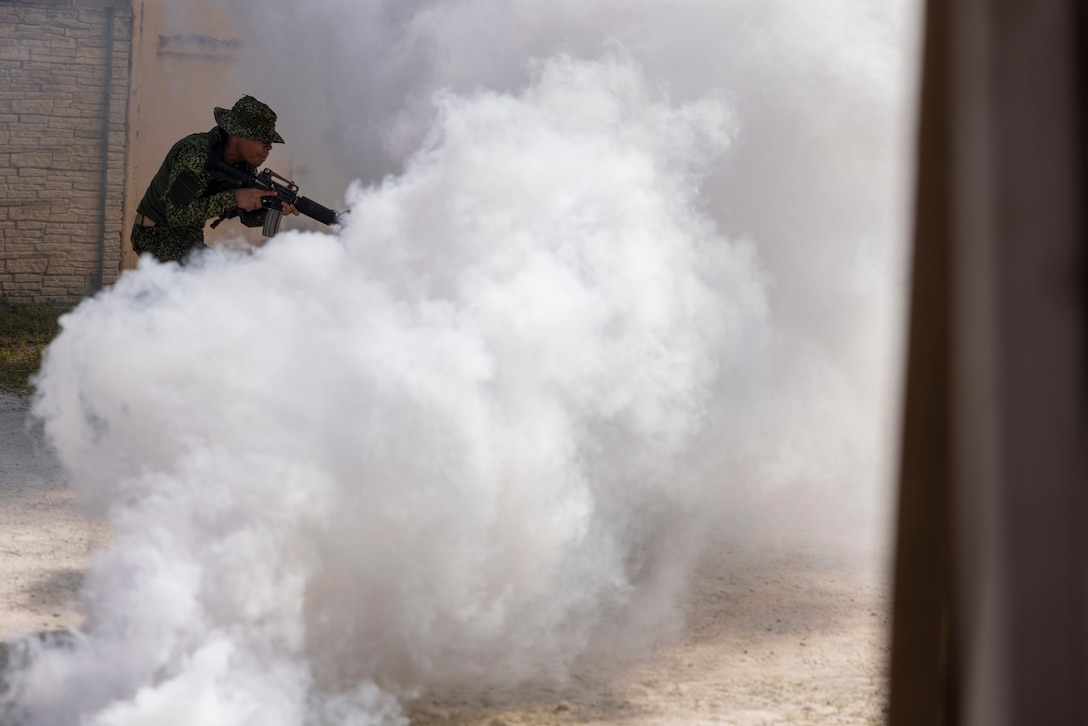A marine with Infantería de Marina Colombiana (Colombian marines) moves through smoke while conducting urban terrain training during exercise UNITAS 2025 at Marine Corps Base Camp Lejeune, North Carolina, Sept. 19, 2025. UNITAS, which is Latin for “unity,” was conceived in 1959 and has taken place annually since first conducted in 1960. This year marks the 66th iteration of the world’s longest running annual multinational maritime exercise. (U.S. Marine Corps photo by Lance Cpl. Payton Goodrich)