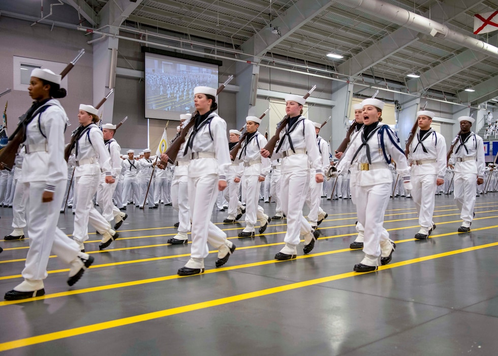 Honor Guard recruits march inside Midway Ceremonial Drill Hall during pass-in-review at U.S. Navy Recruit Training Command, the Navy’s only boot camp, where all enlistees complete about nine weeks of training with over 40,000 annually.