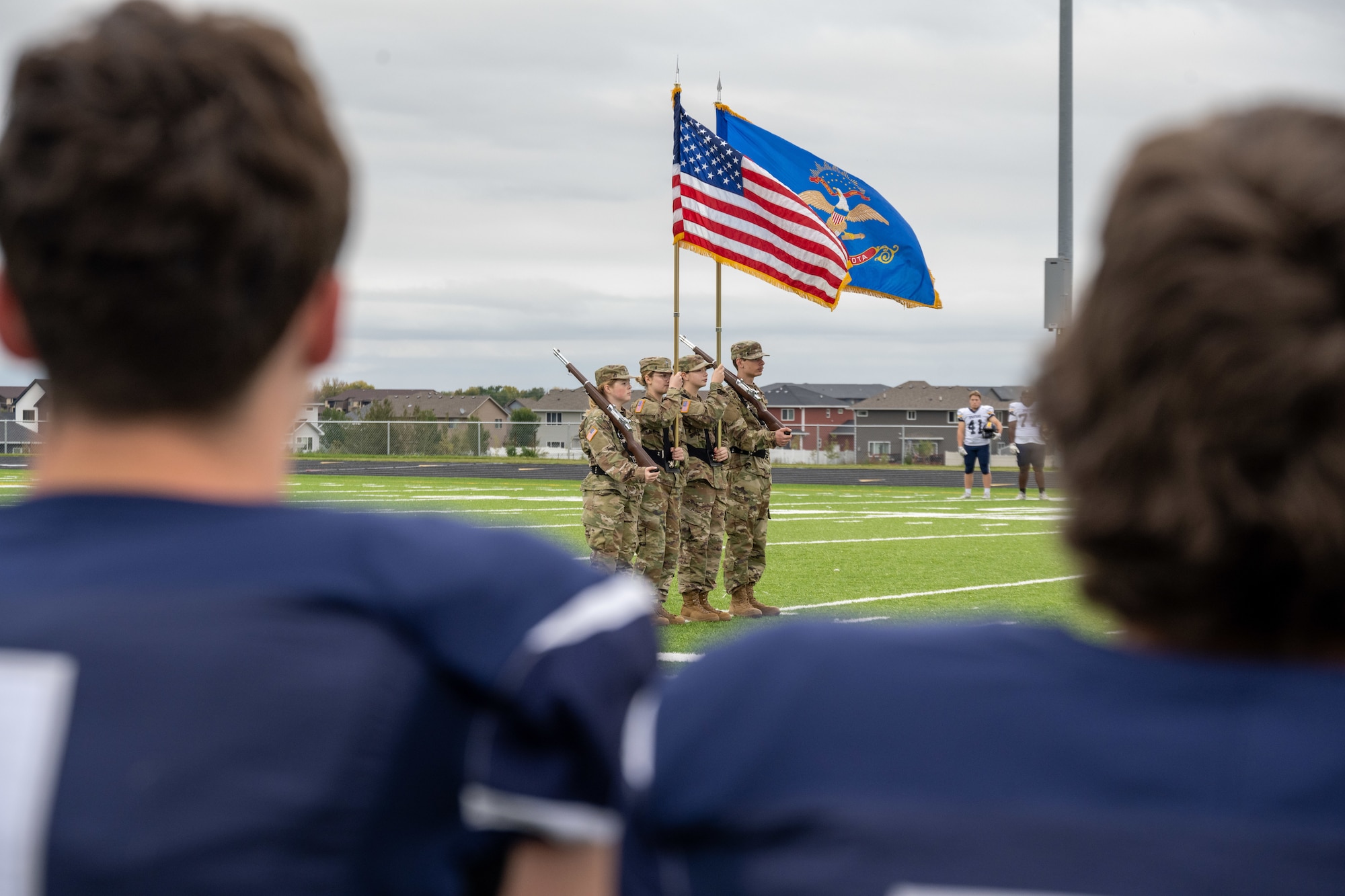 Members of the Minot Air Force Base honor guard present the colors during the national anthem before the Minot North High School football game at Sentinel Stadium in Minot, North Dakota, Sept. 20, 2025. The ceremony preceded a UH-1 Iroquois arrival carrying 5th Bomb Wing and 91st Missile Wing leadership for the game’s opening kickoff. (U.S. Air Force photo by Senior Airman Luis Gomez)