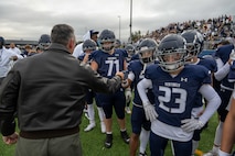 Col. Jesse Lamarand, 5th Bomb Wing commander, fist bumps a Minot North High School football player before the homecoming game at Minot, North Dakota, Sept. 20, 2025. Leadership from the 5th BW and 91st Missile Wing took part in pre-game activities to honor the community and kick off the game. (U.S. Air Force photo by Senior Airman Luis Gomez)