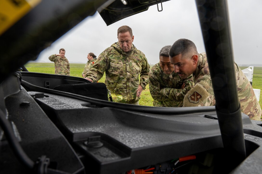 U.S. Air Force Senior Airman Andrew Caballero, 316th Operations Support Squadron radar, airfield and weather systems journeyman, Col. Jun S. Oh, 316th Wing and installation commander, and Chief Master Sgt. Kevin Helms, 316th Wing command chief, look over the sensory summary for the FMQ-19 at Joint Base Andrews, Maryland, Sept. 17, 2025. The sensor summary shows the real time information of the sensors.