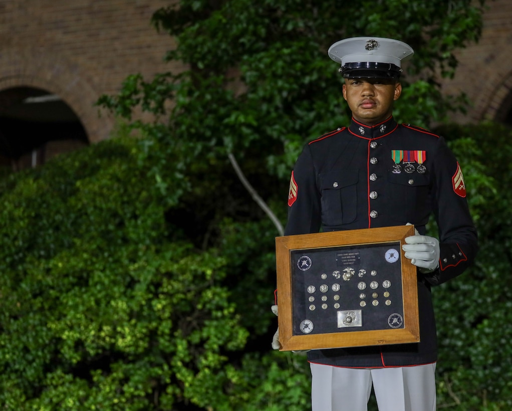 U.S. Marine Corps Cpl. Cameron Holmes, the primary rifle inspector with the U.S. Marine Corps Silent Drill Platoon, poses with the ceremonial “silver buttons” after the Friday Evening Parade at Marine Barracks Washington, D.C., June 27, 2025. Once gold, the buttons have been polished repeatedly, turning silver over generations. These buttons are passed down through each rifle inspector, symbolizing discipline and unbroken legacy of the billet. Holmes is one of a select few to wear the silver brass, carrying the weight of tradition and the responsibility to uphold the Corps’ highest standards in every performance. (U.S. Marine Corps photo by Pfc. Brianna Davidson)