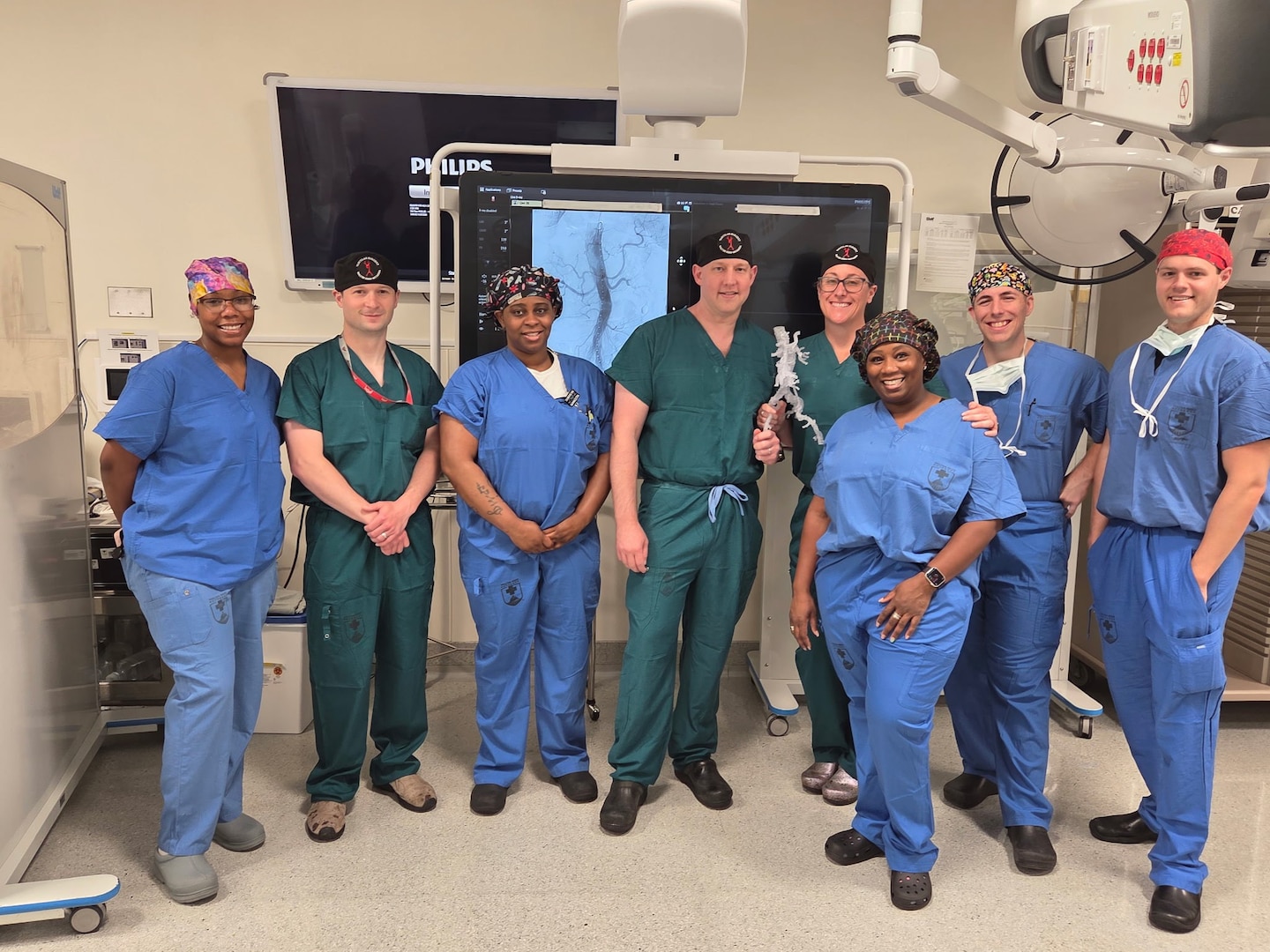 A vascular surgery team poses in an operating room at Walter Reed National Military Medical Center after completing a thoracoabdominal branch endoprosthesis (TAMBE) procedure. It was the first time Walter Reed performed this procedure, making the hospital one of only three in the region qualified to do so.