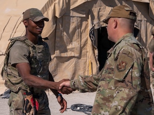 U.S. Air Force Col. James M. Clark, commander of Joint Base Anacostia-Bolling and the 11th Wing, recognizes Airman 1st Class Ja’Mir Denson, assigned to the 723d Combat Air Base Squadron from the 11th Civil Engineer Squadron, during a combat support squadron training at Tyndall Air Force Base, Fla., Sept. 15, 2025.