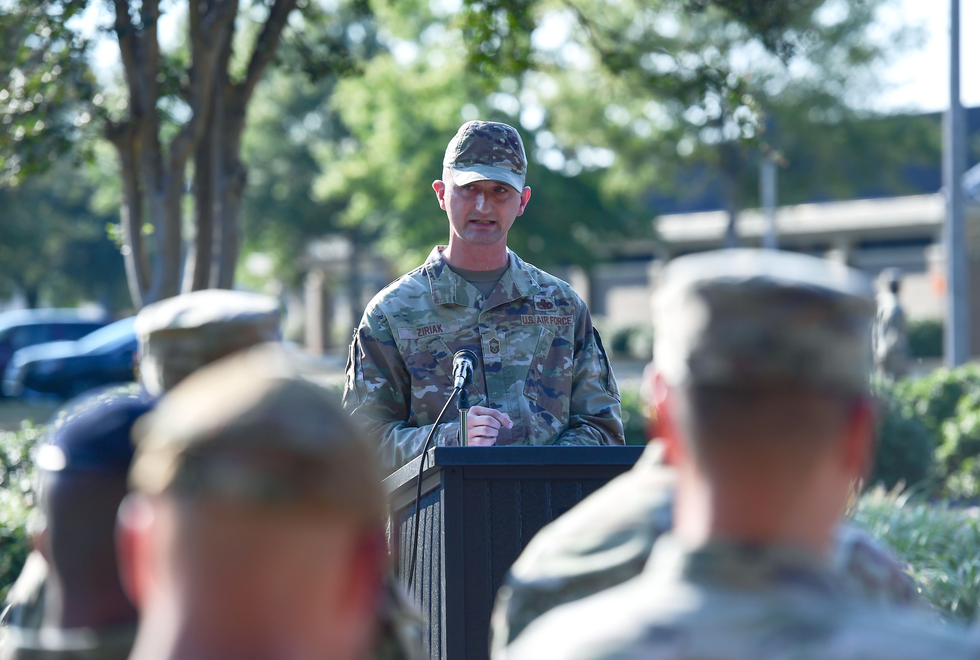 A man in military uniform speaks from behind a podium