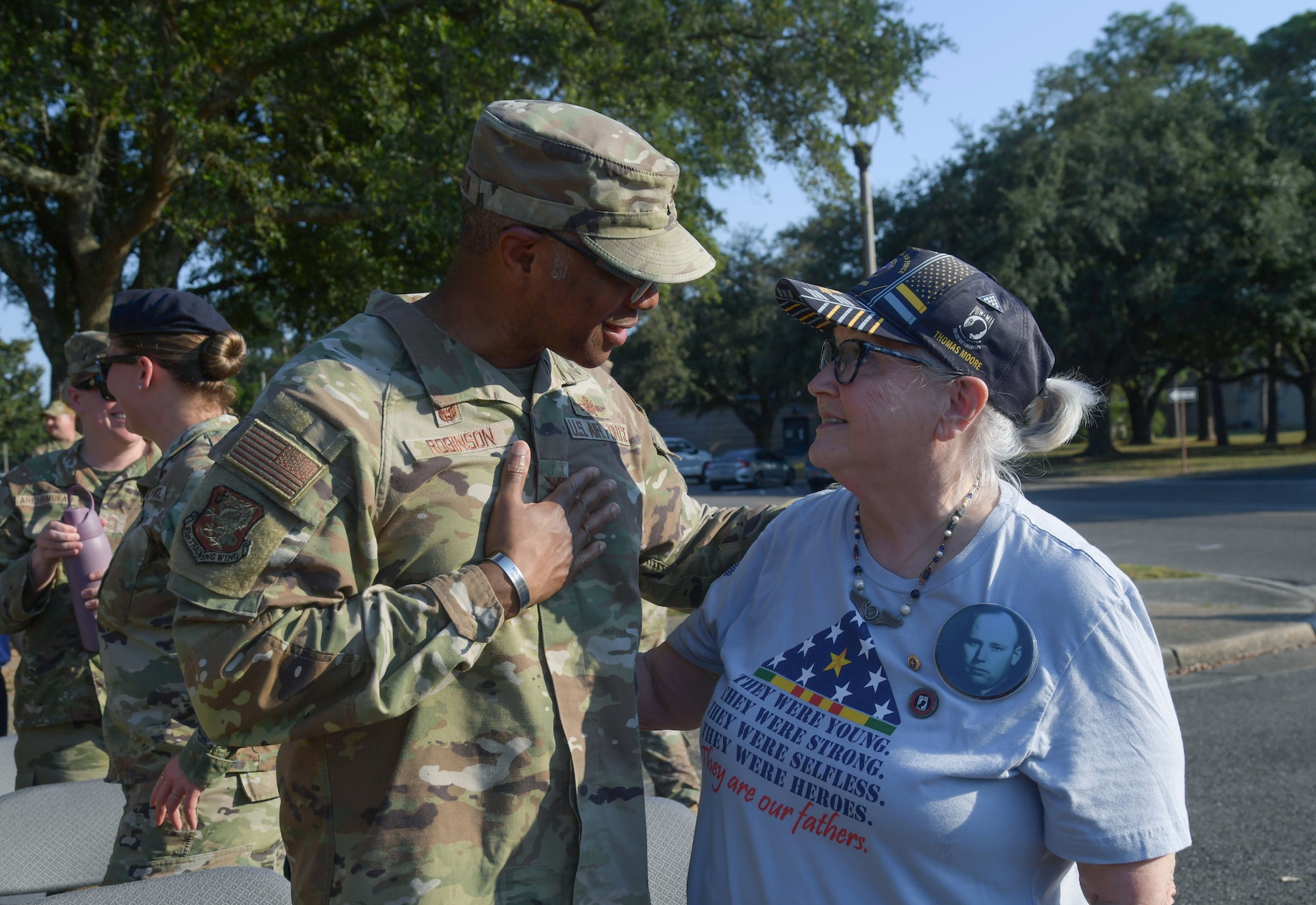 A man in military uniform speaks to a woman