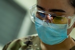 U.S. Air Force Senior Airman Xiomara Soler, 59th Dental Squadron dental technician, watches as U.S. Army Col Evan Hart, 311th Medical Detachment dentist, conducts a dental procedure during AMISTAD 2025 at the Centro de Salud de La Mesa, Panama, Sept. 17, 2025. The exercise provided real-world readiness while bringing dental care to underserved communities in Veraguas Province of Panama. (U.S. Air Force photo by Andrea Jenkins)
