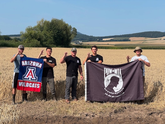 From left to right, Max von Husen, Zachariah Ellwanger, Lt. Col. Rich Ingleby, Carson Criswell, and Jonathan Ellwanger from the University of Arizona pose with their university flag, and the POW/MIA flag in Poland, Aug. 9, 2025.