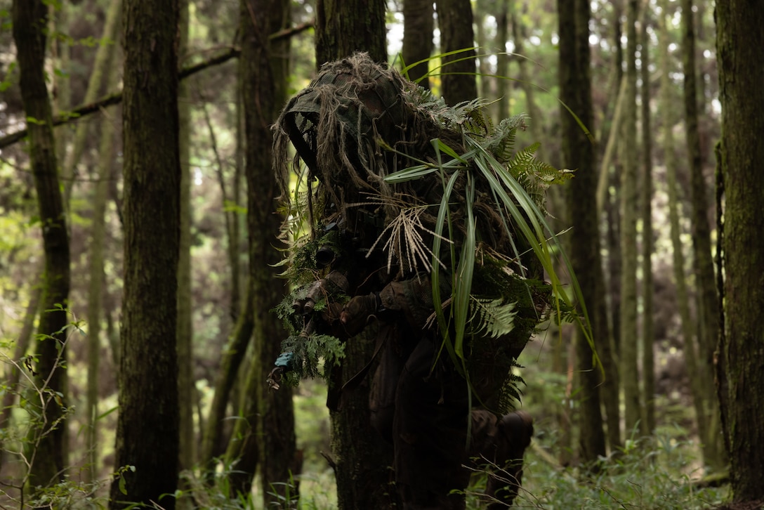 U.S. Marine Corps Cpl. Tyler Pacheco, a rifleman with 12th Littoral Combat Team, 12th Marine Littoral Regiment, 3rd Marine Division, maneuvers through wooded terrain during Resolute Dragon 25 at Oyanohara, Oita Prefecture, Japan, Sept. 20, 2025.