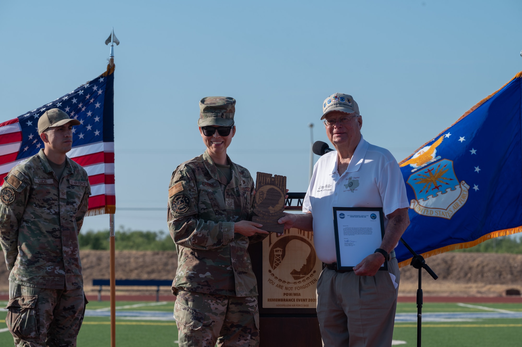 U.S. Air Force Tech. Sgt. Heather Cannon, Concho Valley Air Force Sergeant Association chapter 1066 president, presents Larry Miller, retired major, with a letter of appreciation during the 2025 POW/MIA 24-hour run closing ceremony at Mathis Field, Goodfellow Air Force Base, Texas, Sept. 19, 2025. Miller, who served as a Vietnamese linguist, stepped in as a guest speaker, sharing his ties to the POW/MIA efforts. (U.S. Air Force photo by Senior Airman Quatasia Carter)