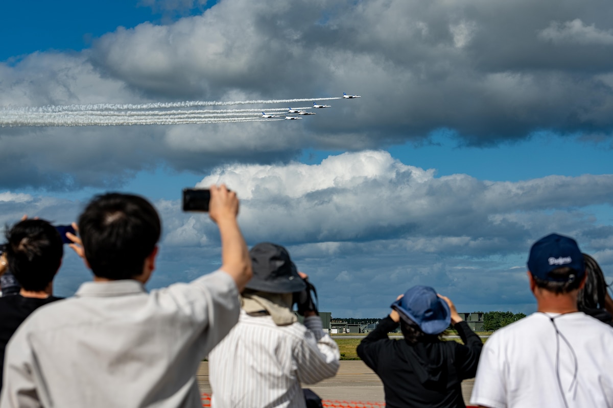 Participants take photos of Japan Air Self-Defense Force’s Blue Impulse aerial demonstration during Air Fest 2025.