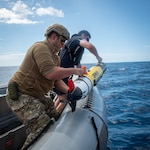 PACIFIC OCEAN (July 18, 2025) Royal New Zealand Navy Able Hydrographic System Operator Blake Todd, assigned to HMNZS Matataua, and U.S. Navy Robotics Warfare Specialist 2nd Class Roddrick Guerra, assigned to Explosive Ordnance Disposal Mobile Unit 5, recover a Remus 100 autonomous underwater vehicle in a rigid-hull inflatable boat assigned to the Lewis B. Puller-class expeditionary sea base USS John L. Canley (ESB 6) off the coast of Australia during Talisman Sabre, July 18, 2025. Talisman Sabre is the largest bilateral military exercise between Australia and the United States advancing a free and open Indo-Pacific by strengthening relationships and interoperability among key allies and partners, while enhancing our collective capabilities to respond to a wide array of potential security concerns. (U.S. Navy photo by Mass Communication Specialist 1st Class W. Chase Stephens)