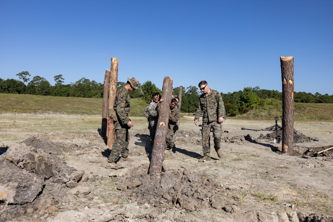 U.S. Marines with Combat Logistics Battalion 22, Combat Logistics Regiment 27, 2nd Marine Logistics Group, stand up logs prior to a demolition range as part of exercise UNITAS 2025 at Marine Corps Base Camp Lejeune, North Carolina, Sept. 20, 2025. UNITAS, which is Latin for “unity,” was conceived in 1959 and has taken place annually since first conducted in 1960. This year marks the 66th iteration of the world’s longest running annual multinational maritime exercise. The exercise trains forces in joint maritime operations that enhance tactical proficiency and increase interoperability with the presence of unmanned air, surface and submarine systems. (U.S. Marine Corps photo by Sgt. Rafael Brambila-Pelayo)