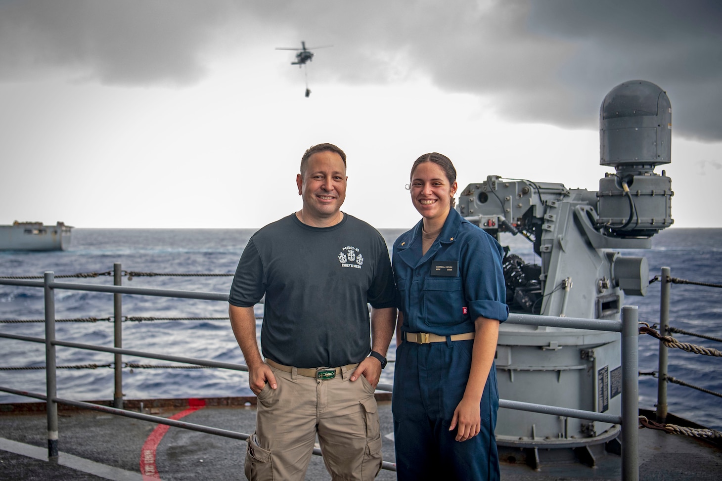 From left, Aviation Machinist's Mate Senior Chief Dan Reyes and his daughter, U.S. Midshipmen 2nd Class Gabriella Reyes, from Miami, Florida, pose for a photo during a vertical replenishment on the fantail aboard the aircraft carrier USS Nimitz (CVN 68) in the South China Sea, June 10, 2025. Nimitz is underway in the U.S. 7th Fleet area of operations on a scheduled deployment, demonstrating the U.S. Navy's unwavering commitment to a free and open Indo-Pacific.