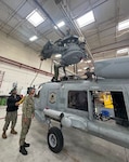Center for Naval Aviation Technical Training students, overseen by Helicopter Maritime Strike Squadron (HSM) 35 staff, perform routine maintenance on a MH-60 helicopter.