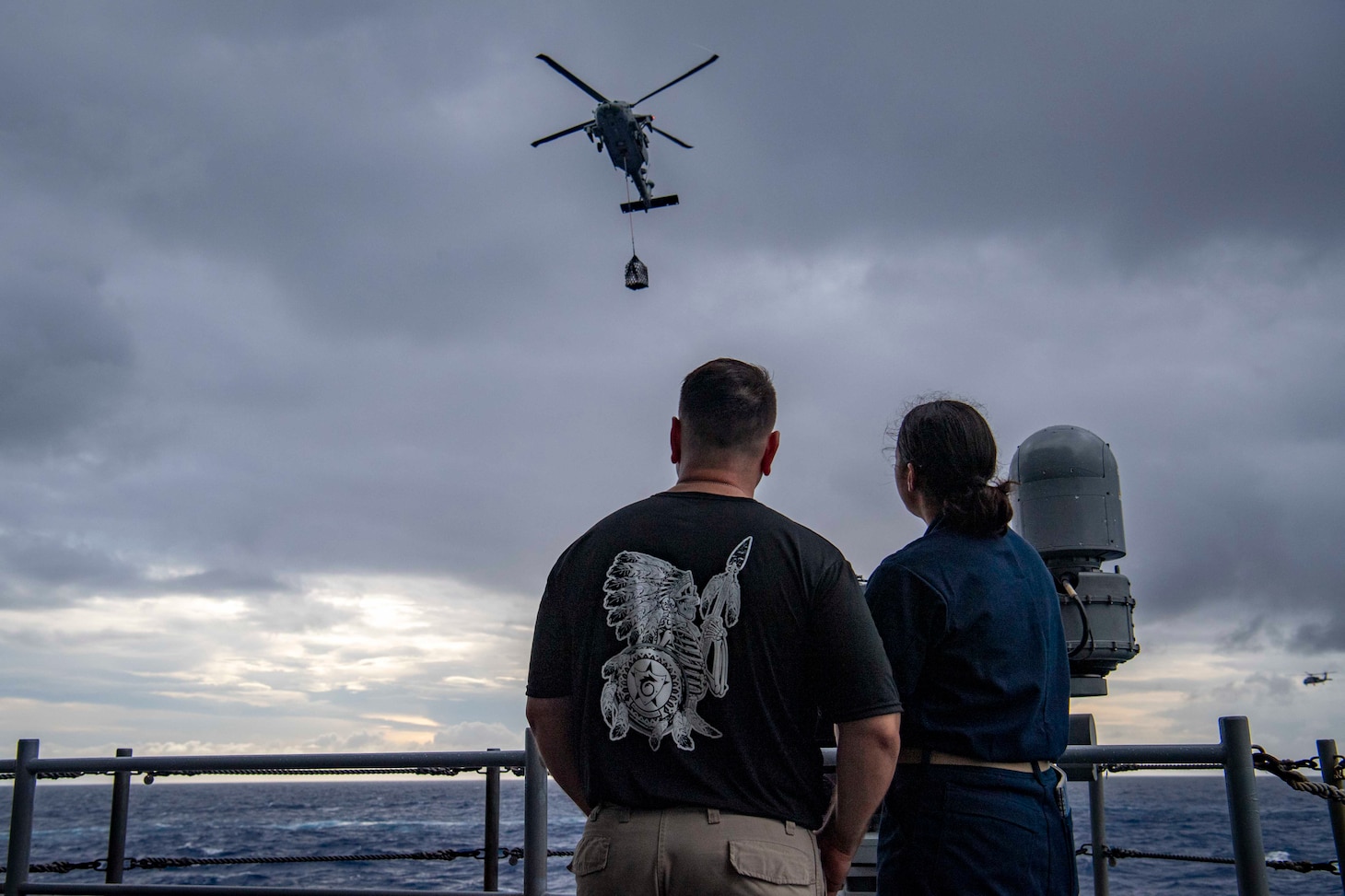 Senior Chief Aviation Machinist's Mate Dan Reyes and his daughter, U.S. Midshipmen 2nd Class Gabriella Reyes, from Miami, Florida, watch a vertical replenishment on the fantail aboard the aircraft carrier USS Nimitz (CVN 68) in the South China Sea, June 10, 2025. Nimitz is underway in the U.S. 7th Fleet area of operations on a scheduled deployment, demonstrating the U.S. Navy's unwavering commitment to a free and open Indo-Pacific.