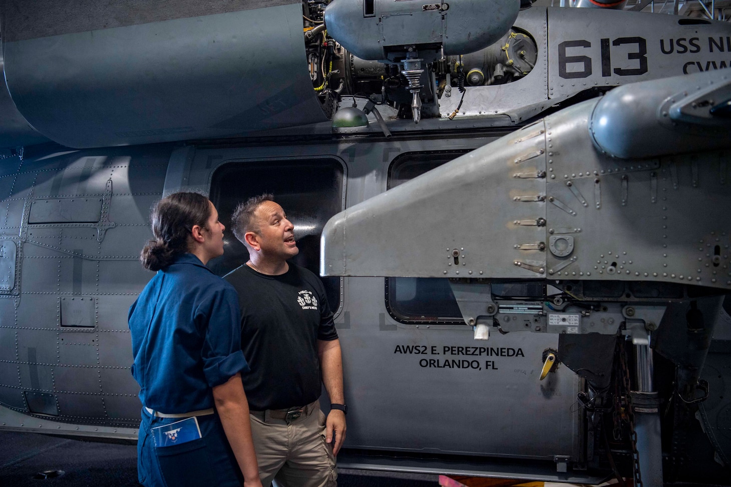 Senior Chief Aviation Machinist's Mate Dan Reyes shows his daughter, U.S. Midshipmen 2nd Class Gabriella Reyes, both from Miami, Florida, An MH-60S Sea Hawk helicopter from his squadron, the “Indians” of Helicopter Sea Combat Squadron (HSC) 6 in the Hanger Bay of the aircraft carrier USS Nimitz (CVN 68) in the South China Sea, June 10, 2025. Nimitz is underway in the U.S. 7th Fleet area of operations on a scheduled deployment, demonstrating the U.S. Navy's unwavering commitment to a free and open Indo-Pacific.