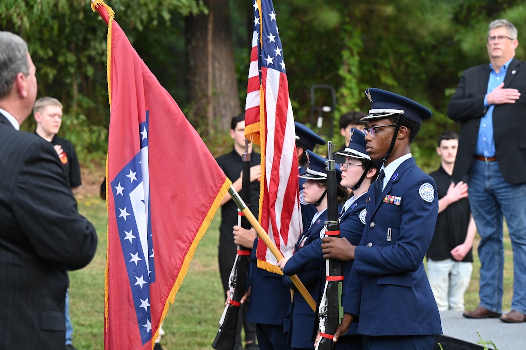 An audience stands for the flag.